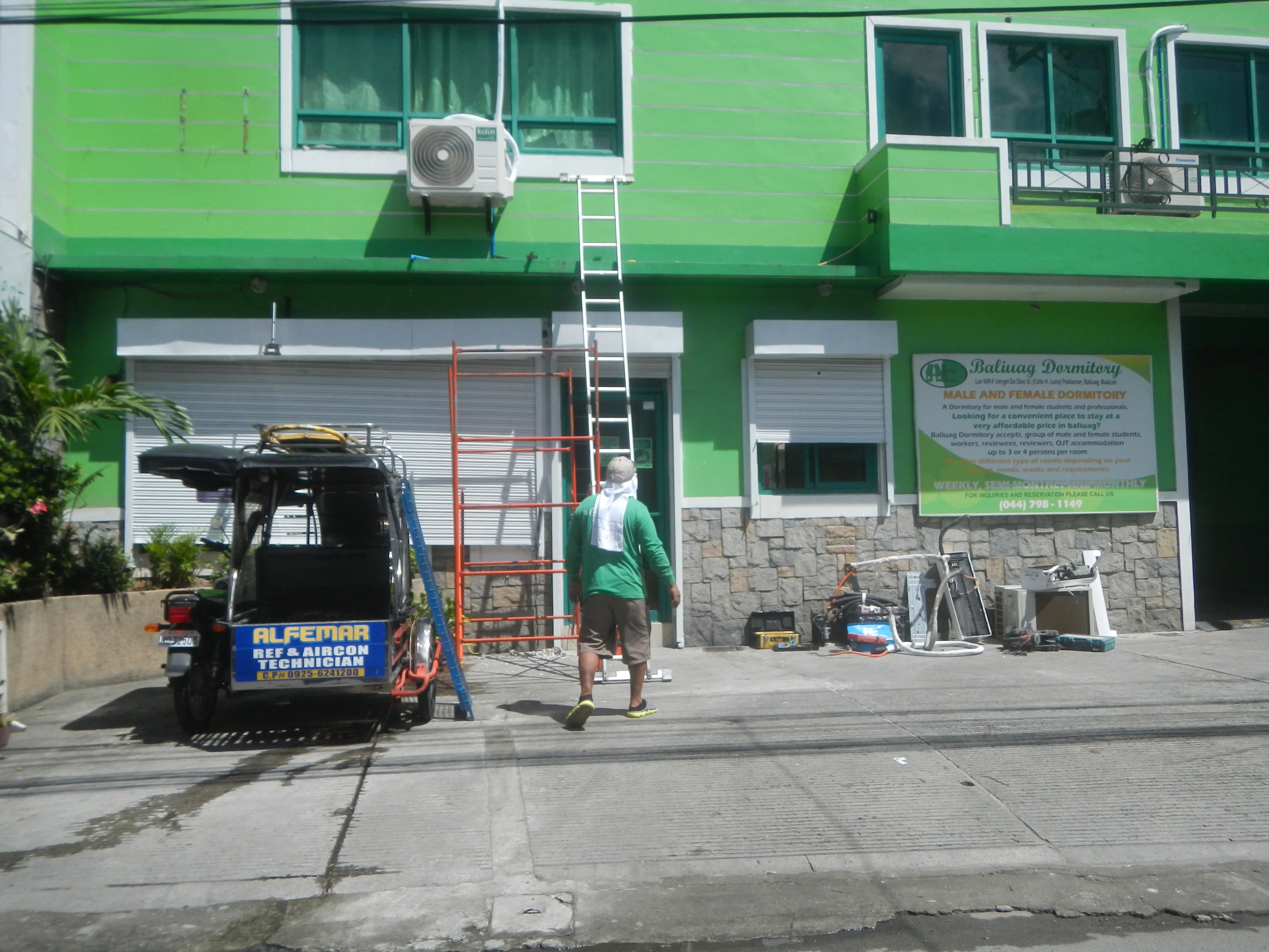 Teknisi membersihkan unit indoor AC dengan peralatan cuci bertekanan