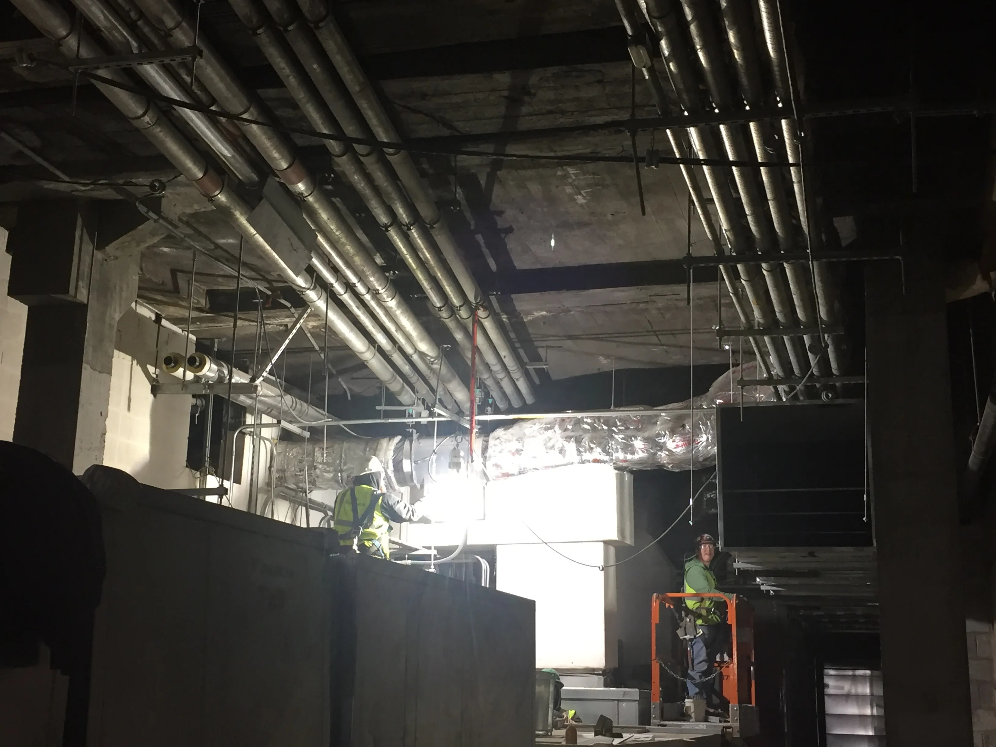 Instalasi unit HVAC berskala industri pada rangka atap gedung komersial